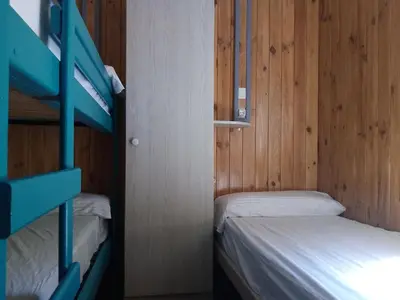 two bunk beds in a room with wooden walls at Camping-Bungalows Altomira in Navajas