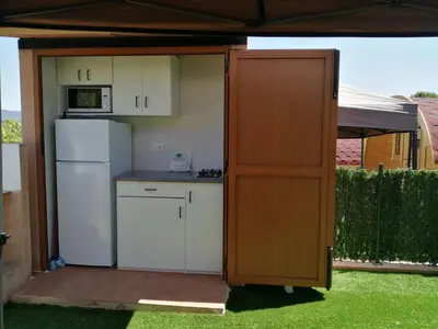 a kitchen with a counter and a refrigerator at Camping-Bungalows Altomira in Navajas