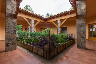 an outside view of a house with a garden at Camping-Bungalows Altomira in Navajas