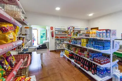 a store aisle with a lot of drinks on shelves at Camping-Bungalows Altomira in Navajas