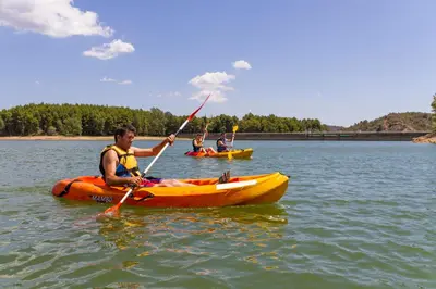 a group of people in kayaks on a lake at Camping-Bungalows Altomira in Navajas