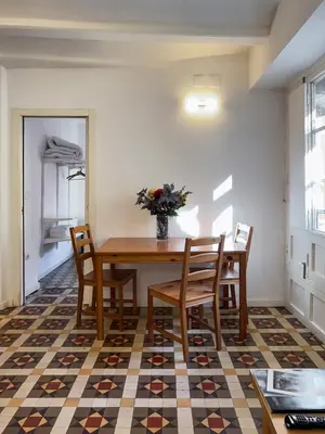 a dining room table with chairs and a vase of flowers at San Jaime Silence in Valencia