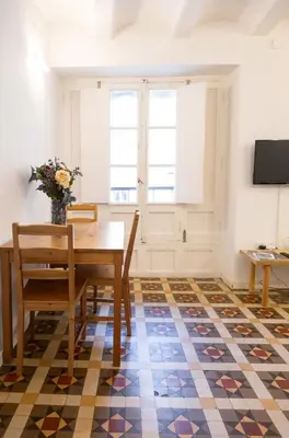 a dining room with a table and chairs on a checkered floor at San Jaime Silence in Valencia