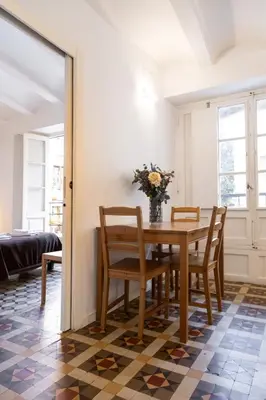 a dining room table with chairs and a vase of flowers at San Jaime Silence in Valencia