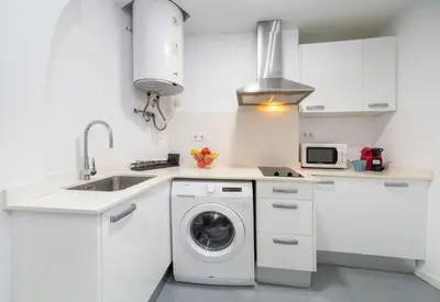 a white kitchen with a washing machine and a sink at San Jaime Silence in Valencia