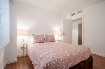 a bedroom with a large bed in a white room at Hi Valencia Apartments - Jorge Juan in Valencia