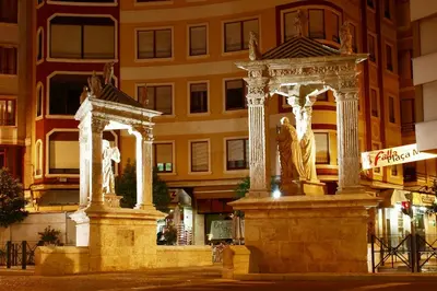 two statues in front of a building at night at Hotel Avenida Plaza in Alzira