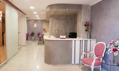 a lobby with a counter with chairs and flowers at Hotel Avenida Plaza in Alzira