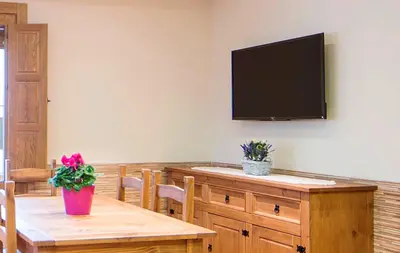 a dining room with a table and a flat screen tv at Casa Rural Francisca in Requena