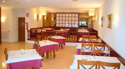 a dining room with tables and chairs in a restaurant at Hotel Carabela 2 in Cullera