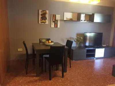 a dining room with a table with chairs and a television at Florazar de Ensueño in Cullera