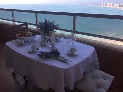 a table with wine glasses and flowers on a balcony at Florazar de Ensueño in Cullera