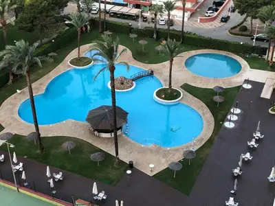 an overhead view of two pools with palm trees and umbrellas at Florazar de Ensueño in Cullera