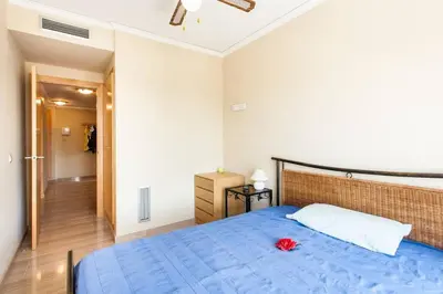 a bedroom with a blue bed with a red flower on it at Biopark View Apartment in Valencia
