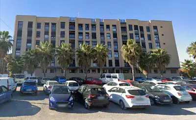a parking lot with cars parked in front of a building at Biopark View Apartment in Valencia