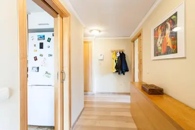 a hallway with a door leading into a room with a refrigerator at Biopark View Apartment in Valencia