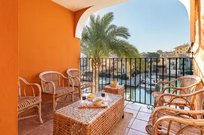 a patio with tables and chairs and a balcony at Travel Habitat Casa con embarcadero. in Port Saplaya