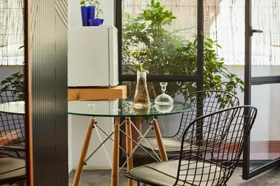 a glass table and chairs in a room with plants at Bubusuites in Valencia