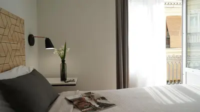 a bedroom with a bed with a window and a table at MD Design Hotel - Portal del Real in Valencia
