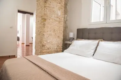 a bedroom with a white bed with a brick wall at Ambrosio Flats Valencia - El Carmen in Valencia