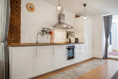 a kitchen with white cabinets and a brick wall at Habana Apartment in Valencia