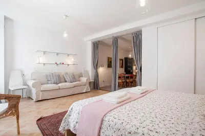 a white bedroom with a bed and a couch at Habana Apartment in Valencia