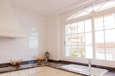 a white kitchen with a sink and a window at MD Villa Cullera Cap Blanc in Faro de Cullera