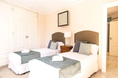 two beds in a room with white walls at MD Villa Cullera Cap Blanc in Faro de Cullera