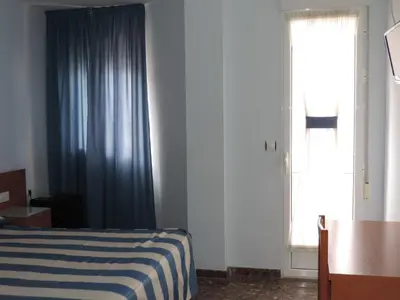 a bedroom with a bed and a large window at Hotel Costa San Antonio in Cullera