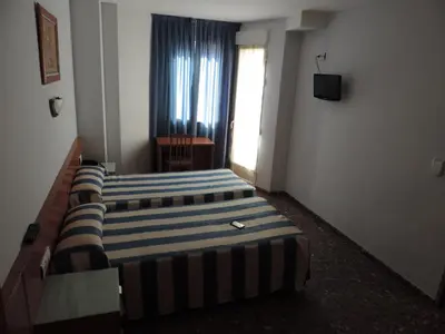 a bedroom with two beds in a room with a window at Hotel Costa San Antonio in Cullera
