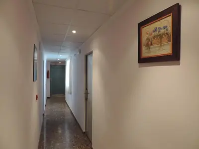 a hallway in an office building with a painting on the wall at Hotel Costa San Antonio in Cullera