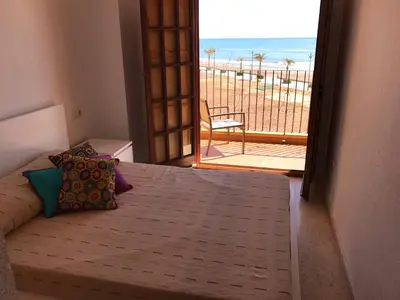 a bedroom with a bed with a view of the beach at Apartamento PortSaplaya in Port Saplaya