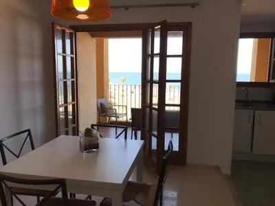 a kitchen and dining room with a table and chairs at Apartamento PortSaplaya in Port Saplaya