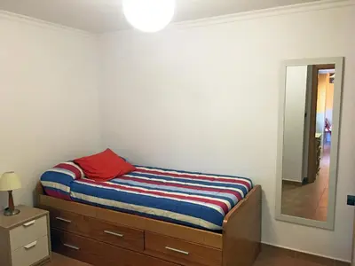 a small bedroom with a bed and a mirror at Casa Cabanyal in Valencia