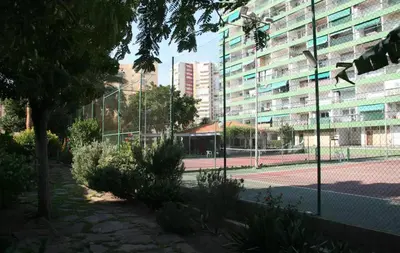 a tennis court in front of a building at Marenostrum view in Playa Pobla de Farnals