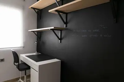 a office with a desk and a black wall at Attic Valencia Beach in Valencia