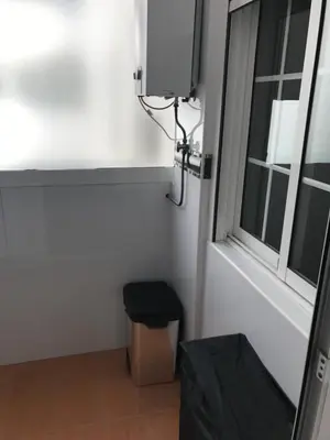 a small room with a window and a trash can at Attic Valencia Beach in Valencia
