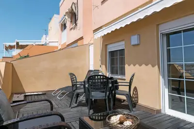 a patio with chairs and a table on a balcony at Attic Valencia Beach in Valencia