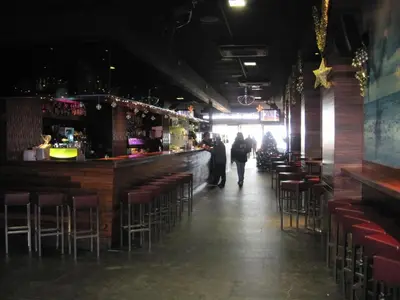 a room with a bar with chairs and a person walking through it at El Globo in Valencia