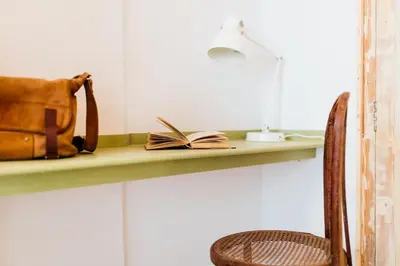 a book on a shelf with a bag and a chair at OttoH Charm Stay in Valencia