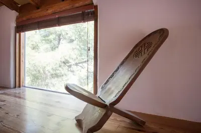 a wooden chair sitting in a room with a window at Ca Carmela casa con Encanto con Piscina 