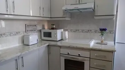 a kitchen with white cabinets and a white microwave at Casa de Maria in Valencia