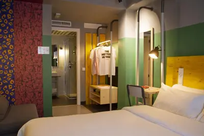 a bedroom with a bed and a dressing room with a dresser at room00 Valencia Hostel in Valencia
