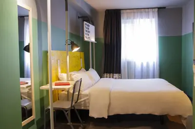 a bedroom with a bed and a table and a window at room00 Valencia Hostel in Valencia