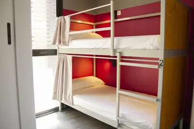 a bunk room with white bunk beds in it at room00 Valencia Hostel in Valencia