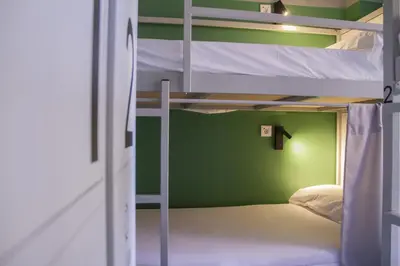 a room with two bunk beds and a green wall at room00 Valencia Hostel in Valencia