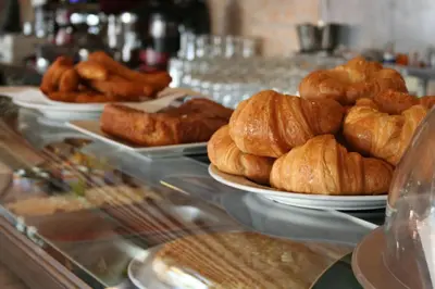 a buffet line with plates of croissants and other pastries at Hotel Playa Canet in Canet de Berenguer