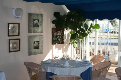 a dining room with a table with chairs and a blue ceiling at Hotel Playa Canet in Canet de Berenguer