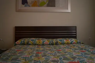 a bed with a colorful comforter in a bedroom at La perla de oasis in Lliria