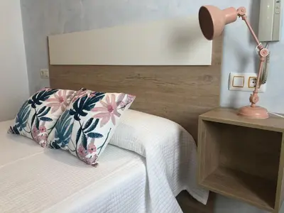 a bedroom with a bed with a pillow and a lamp at Hotel Valldigna in Tavernes de Valldigna
